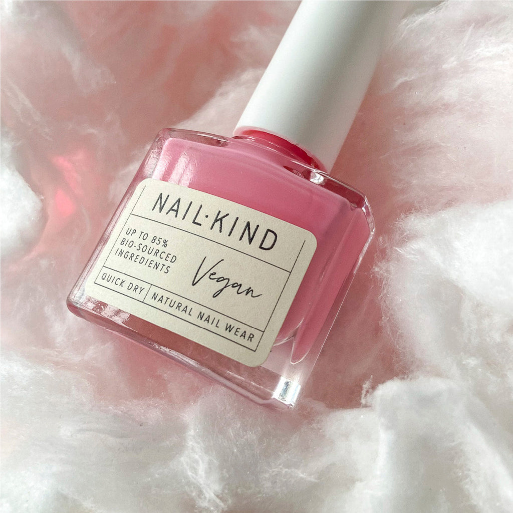 A candy pink long-wearing and easy to apply nail varnish  lying on a bed of cotton wool